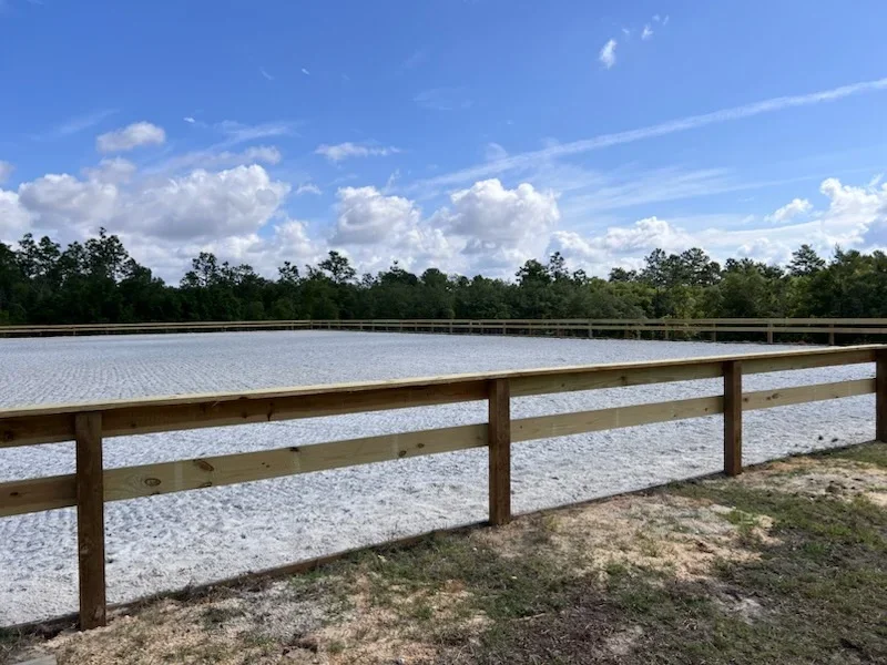 Two-rail wooden fence with pressure-treated timber posts along waterfront property
